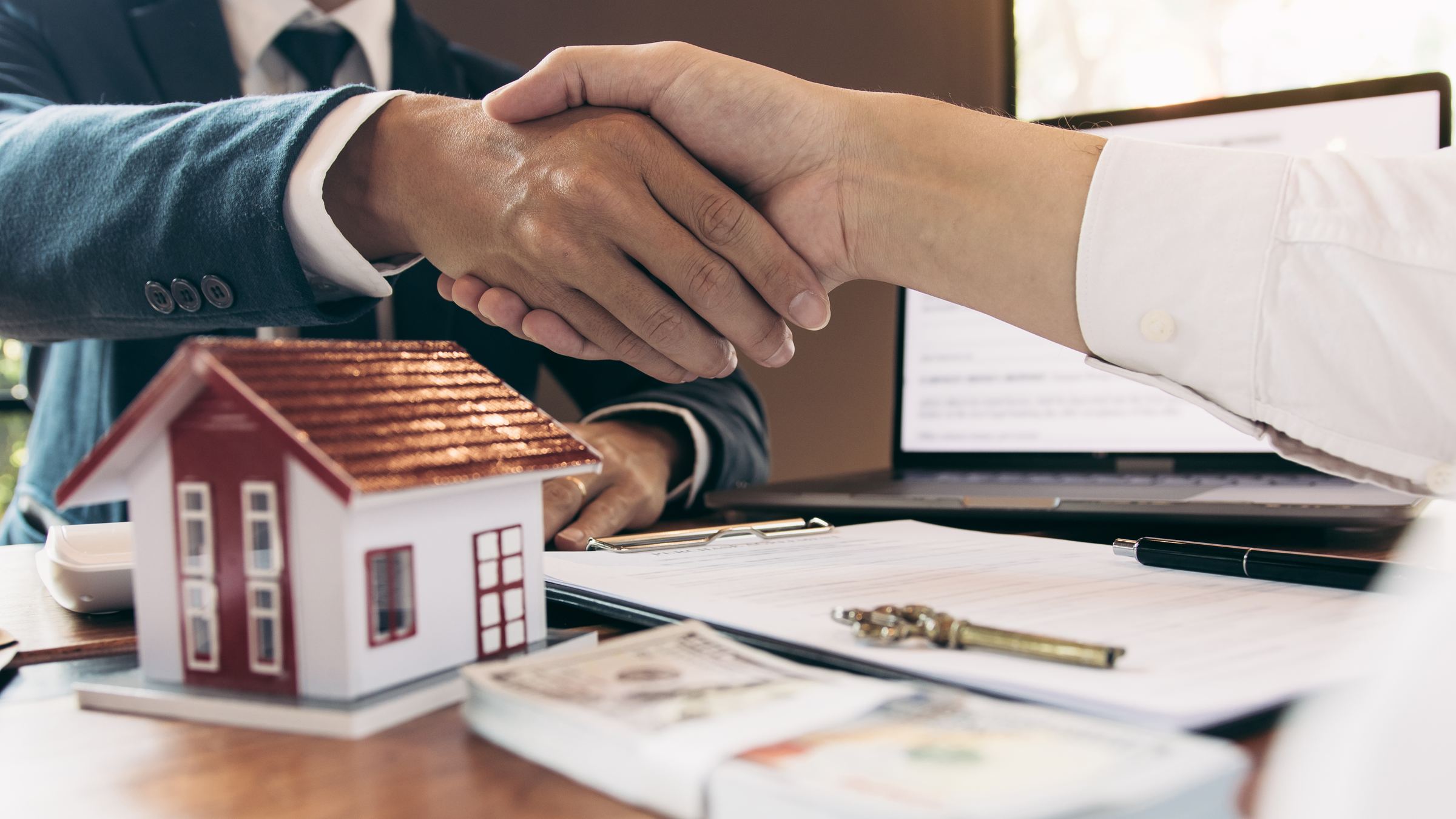 A handshake over the keys to a sold home