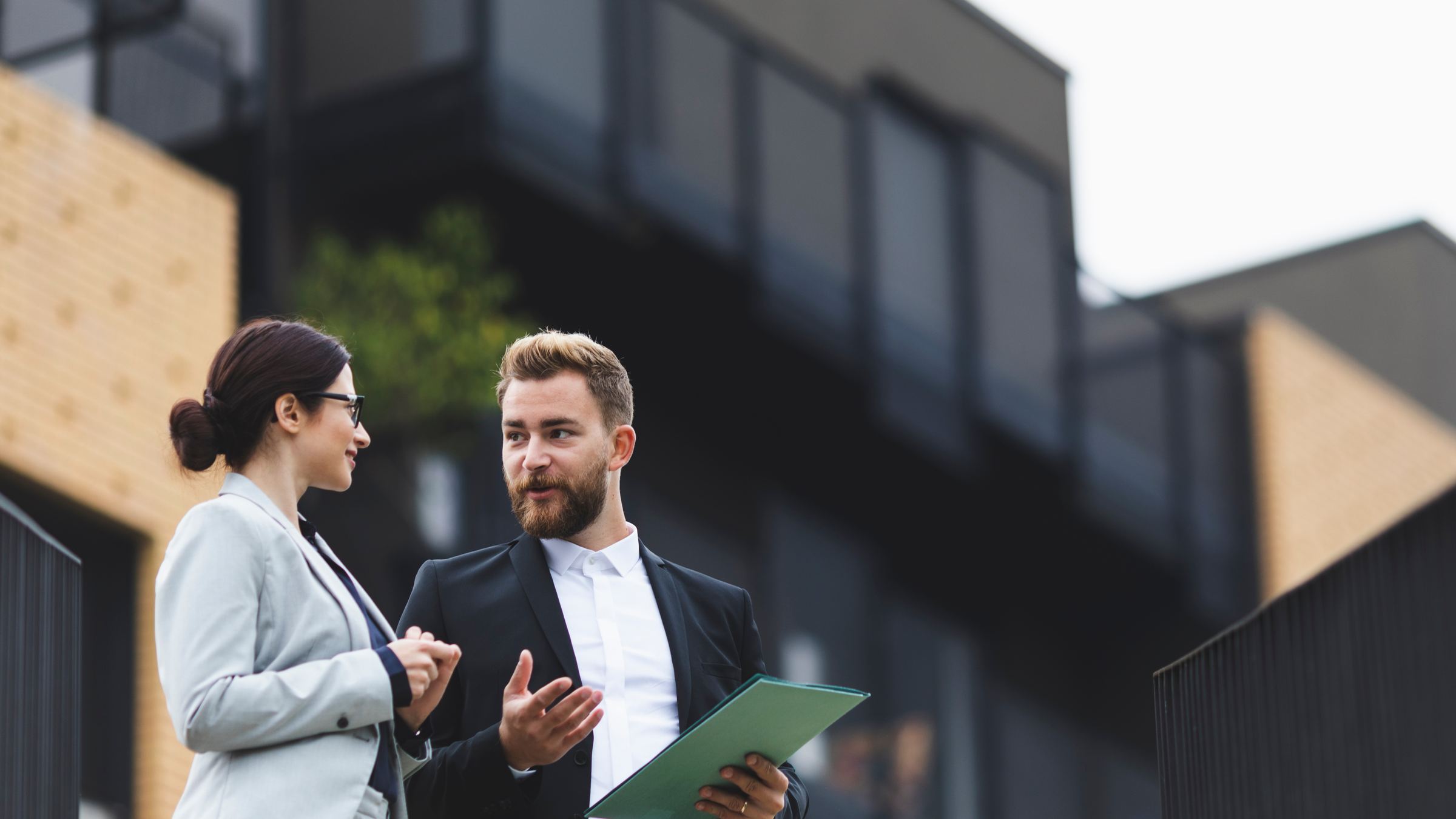Two professionals in conversation outside an office