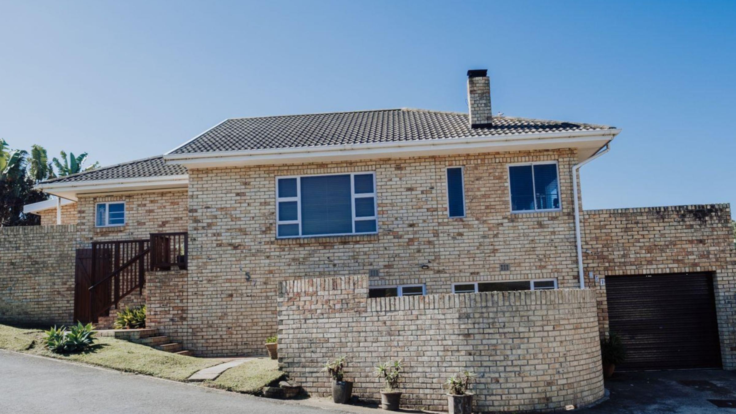 A brick family home on a sunny street